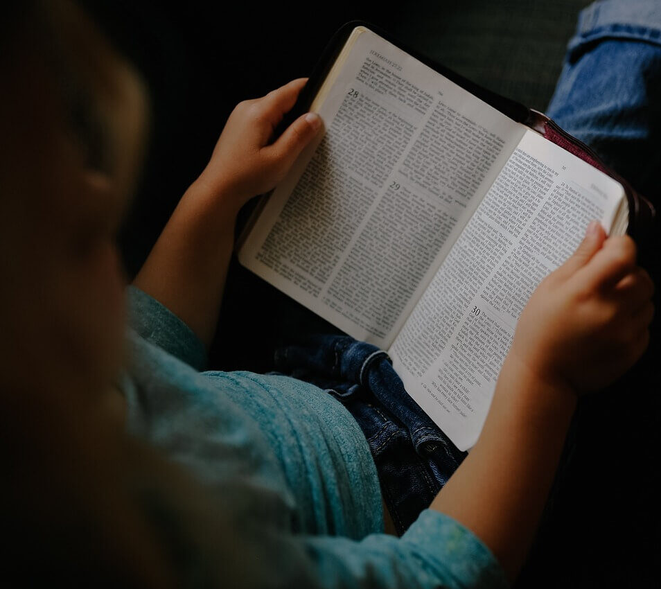 Copil citind Biblia